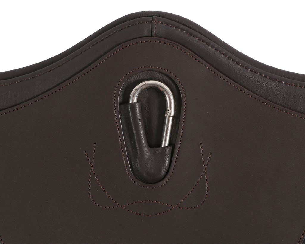 A close-up image of the Stud Guard Girth Comfort. It is made of soft padded leather with strong elastic ends. The girth features NDM cow sorting padding, leather with matching stitching, and 38mm heavy-duty elastic. It is designed for durability with top-quality leather and stainless steel buckles. The girth provides optimal protection and comfort for horses during jumping sessions. It has a center D ring for attaching breastplates and ensures a secure fit with its strong elastic ends. 